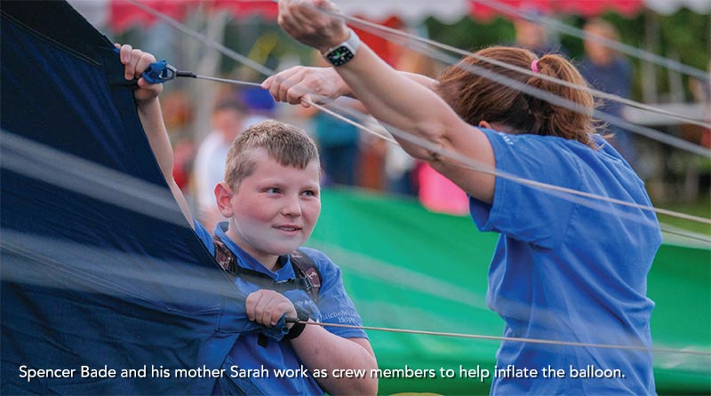 Spencer Bade and his mother Sarah work as crew members to help inflate the balloon.