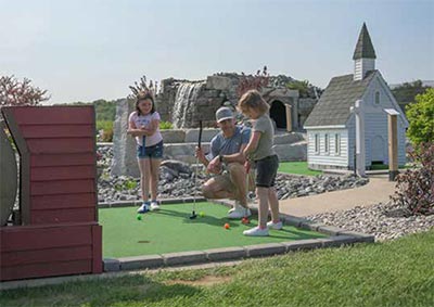 Little girls playing mini-golf