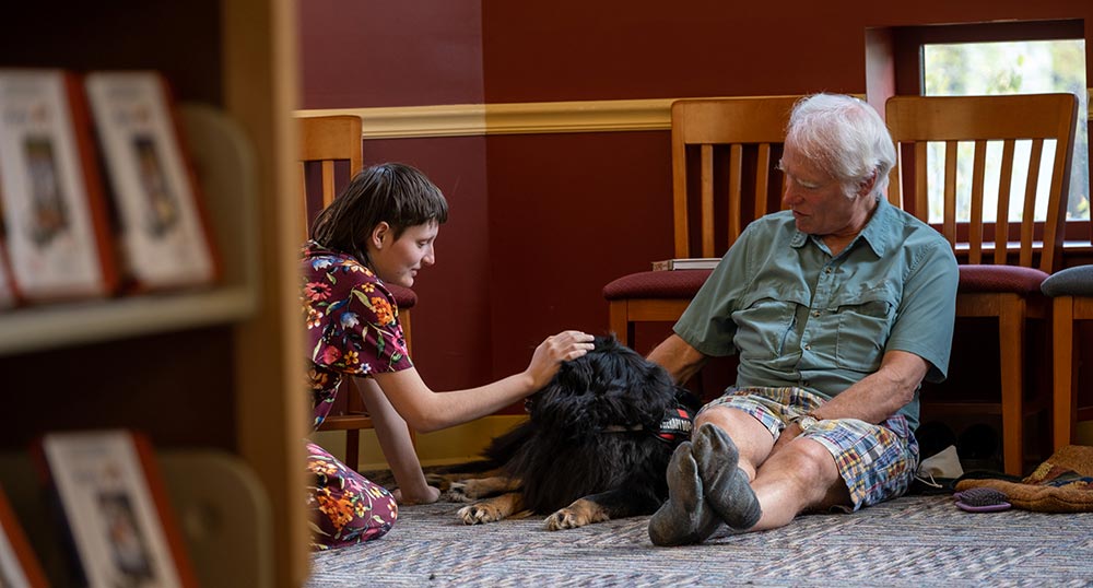 Lizzy Gordon of Minot with Michael Fralich and therapy dog, Mocha